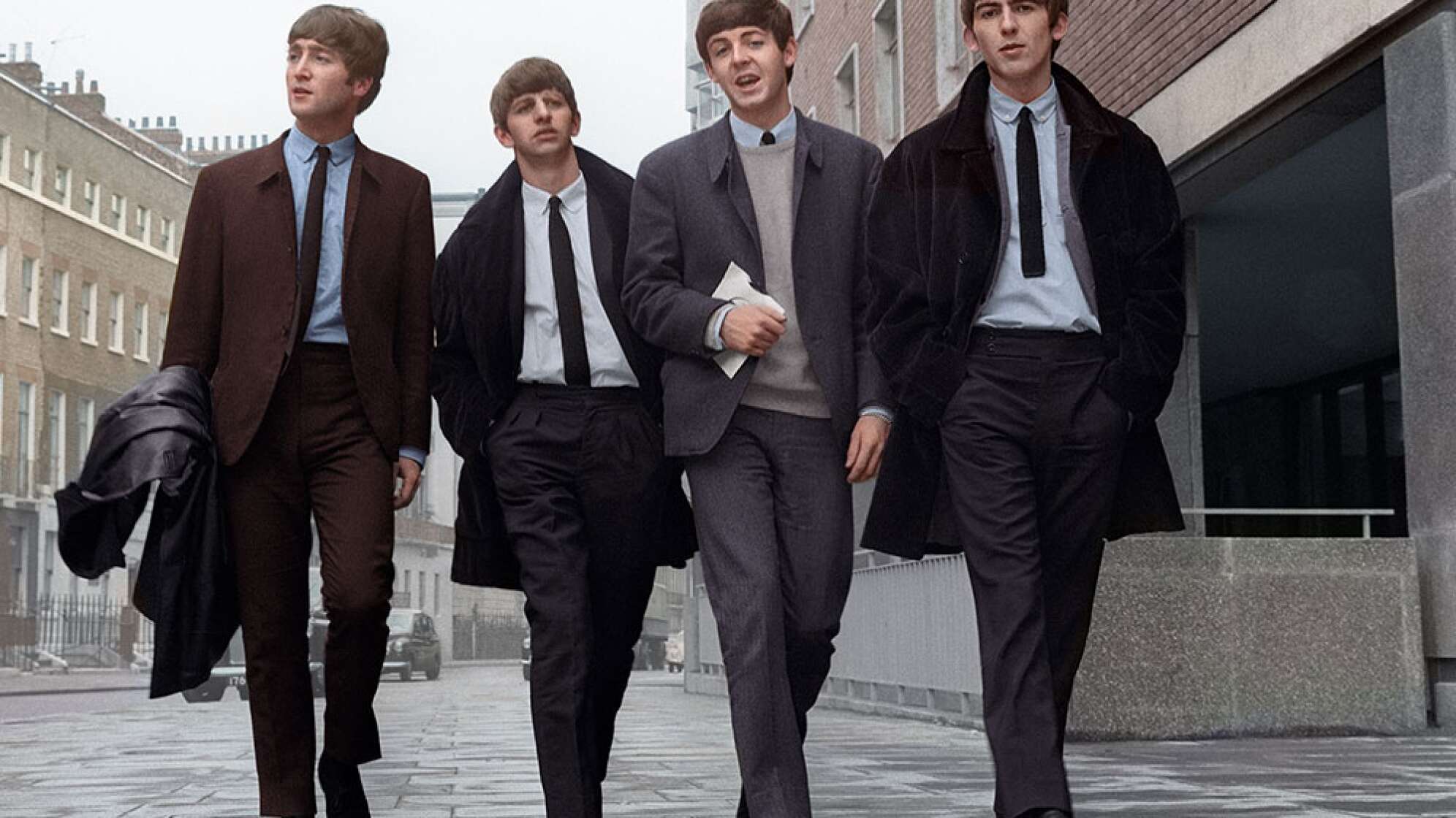 Die Mitglieder der Beatles laufen eine Straße entlang